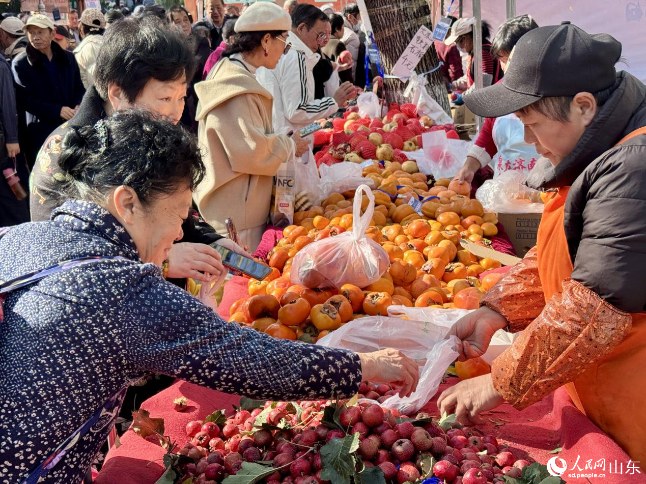 攤位前，游客正在挑選心儀的水果。人民網(wǎng) 鄭昕橋攝