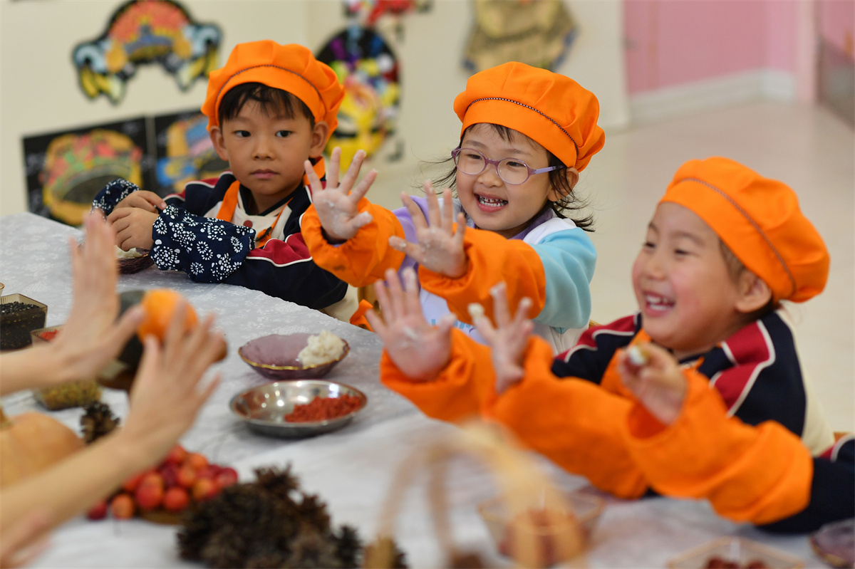 2025年10月29日，在山東省青島市城陽區(qū)棘洪灘街道中心幼兒園開展的重陽傳統(tǒng)文化體驗活動上，老師擊掌鼓勵小朋友們學習重陽糕制作。王海濱攝