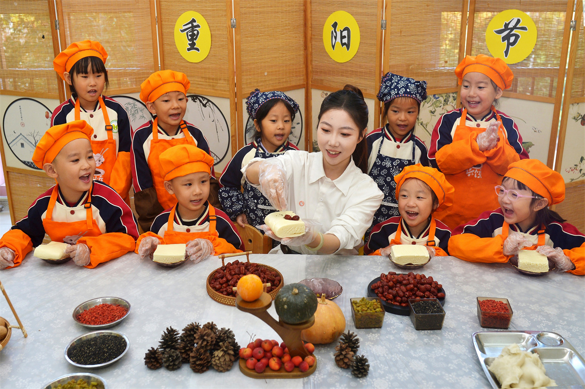 2025年10月29日，在山東省青島市城陽區(qū)棘洪灘街道中心幼兒園開展的重陽傳統(tǒng)文化體驗活動上，老師為小朋友講解重陽糕制作步驟。王海濱攝