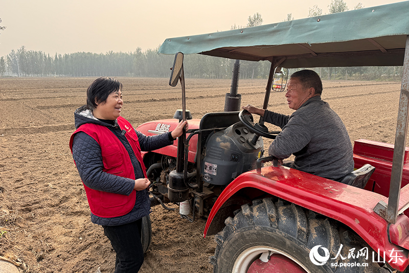 杜立芝和機(jī)播手交流播種注意事項(xiàng)。人民網(wǎng)記者 劉祺攝