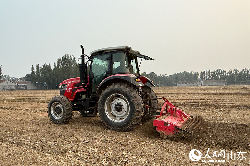 農(nóng)機(jī)手李玉華開著拖拉機(jī)馳騁在田野里。人民網(wǎng)記者 劉祺攝