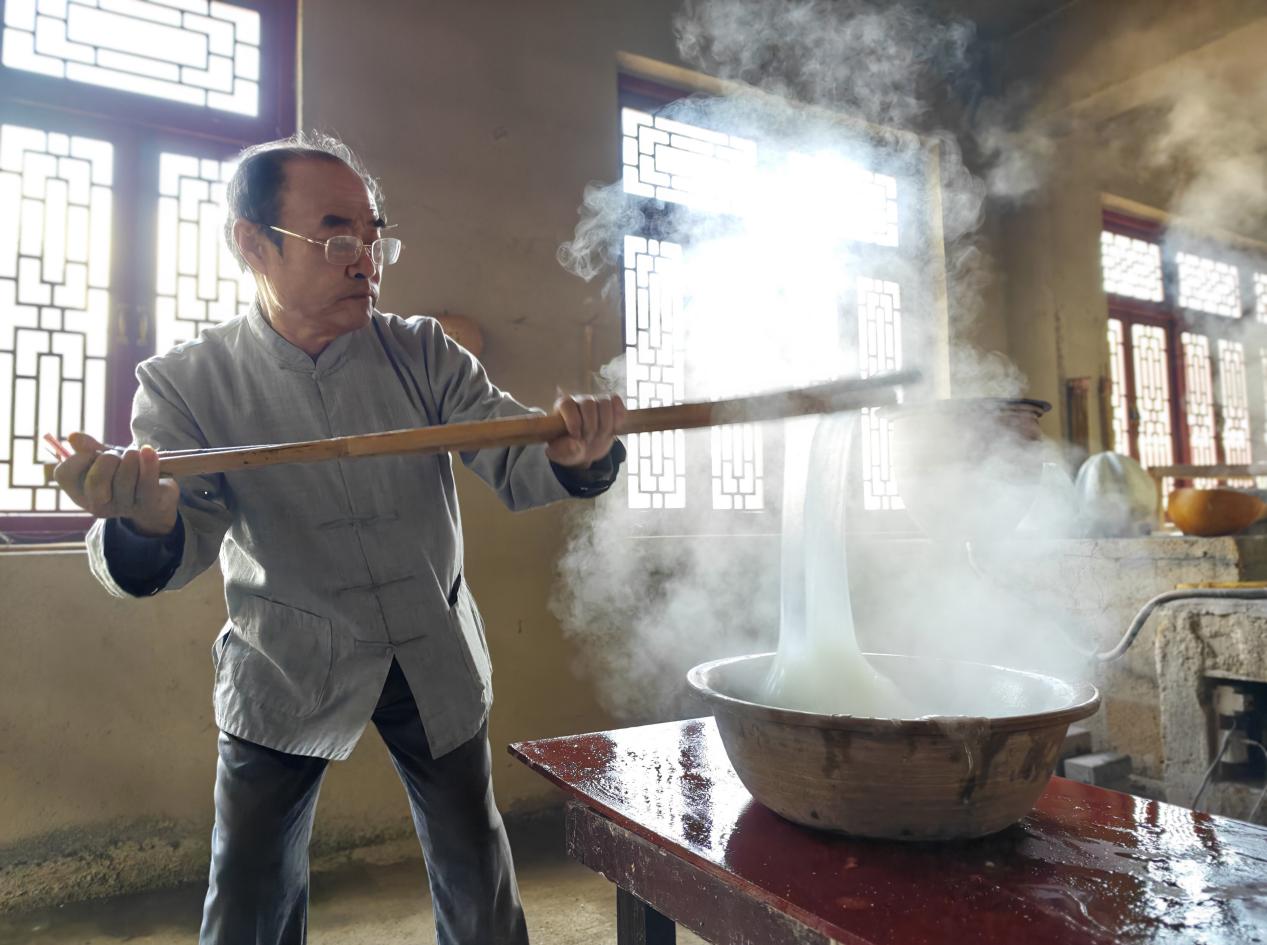 國(guó)家非物質(zhì)文化遺產(chǎn)代表性傳承人郭蘭堂演示傳統(tǒng)龍口粉絲制作中的打糊環(huán)節(jié)。周揚(yáng)攝
