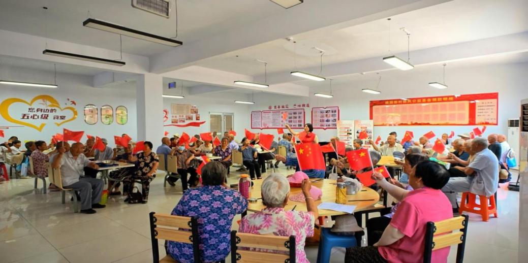 7月1日，桃園新村黨委領(lǐng)辦暖心食堂項目，開餐前教老人唱紅歌、做手勢操。