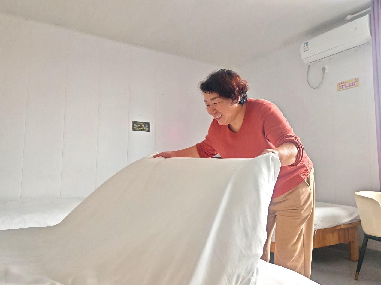 圖為邊曾蘭正在整理賓館房間