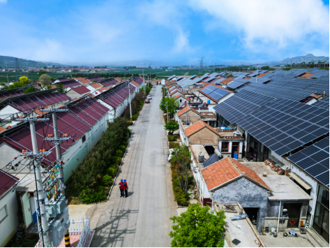 國網(wǎng)沂水縣供電公司員工在沂水縣寺前官莊村巡檢10千伏線路，服務(wù)分布式光伏示范項目建設(shè)
