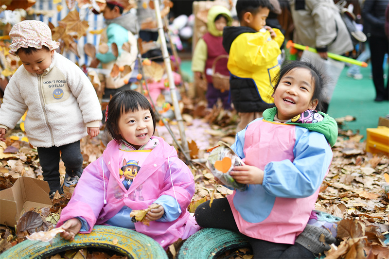 2025年11月25日，小朋友在山東省青島市市北區(qū)高安路幼兒園開展的“色彩日”主題活動上撿拾多彩落葉。王海濱攝