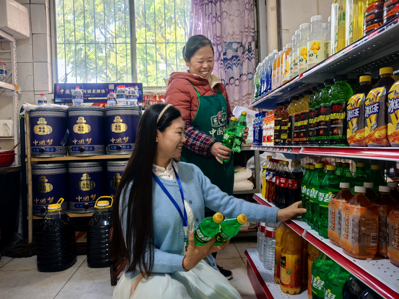 工作人員幫助老年零售戶優(yōu)化商品陳列