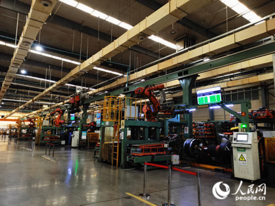 智能工廠內(nèi)一排排忙碌的智能手臂有條不紊地運(yùn)作。人民網(wǎng)記者 栗翹楚攝