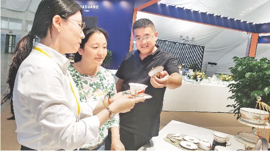 華光國瓷工作人員在向觀展市民介紹新推出的“好運(yùn)連連”中秋禮系列產(chǎn)品。